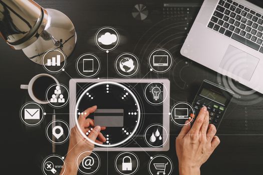 Internet shopping concept.Top view of hands working with laptop and credit card and tablet computer on dark wooden table background with Vr diagram