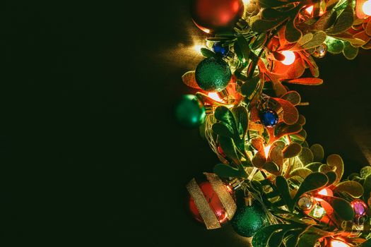 Greeting Season concept.Christmas wreath with decorative light on dark wood background