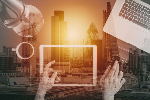 Internet shopping concept.Top view of hands working with laptop and credit card and tablet computer on dark wooden table background with buildings exposure