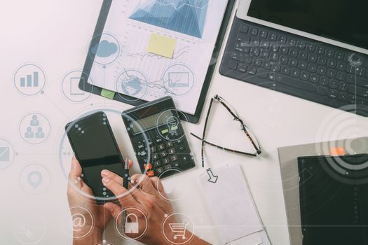 top view of businessman hand working with finances about cost and calculator and latop with mobile phone on withe desk in modern office with VR icon diagram