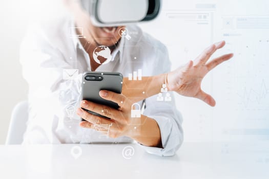 businessman wearing virtual reality goggles in modern office with mobile phone using with VR headset with screen icon diagram