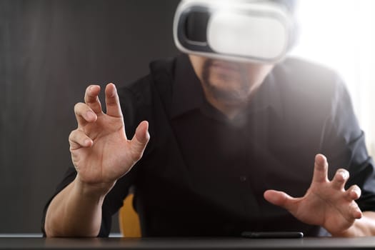 businessman wearing virtual reality goggles in modern office with mobile phone using with VR headset