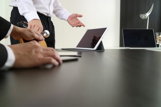 Medical co working concept,Doctor working with smart phone and digital tablet and laptop computer to meeting his team in modern office at hospital