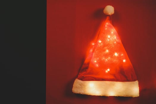 Greeting Season concept.Santa Claus hat with christmas light on red and green background