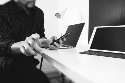 businessman working with smart phone and digital tablet and laptop computer in modern office ,black and white