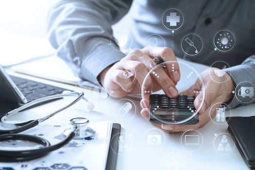 Healthcare costs and fees concept.Hand of smart doctor used a calculator for medical costs in modern hospital with VR icon diagram