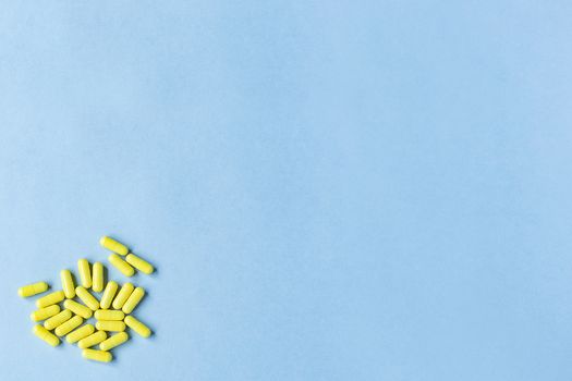 Yellow capsules on a blue background. Omega-3 vitamins. food Supplement. Fish oil in capsules. Free space. space for text. copy space. blurred background. Selective focus. banner. concept of medicine.