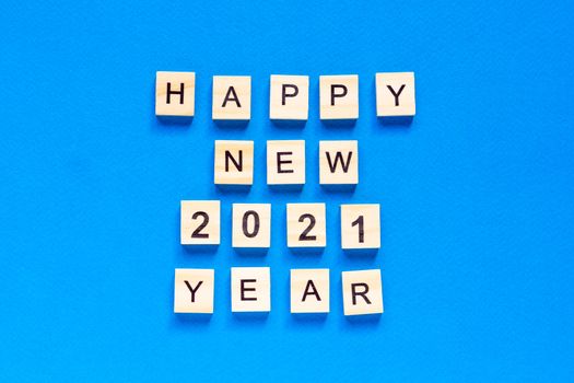 Happy New year written in wooden letters on a blue background. Happy new year 2021. top view. flat layout. space for text.