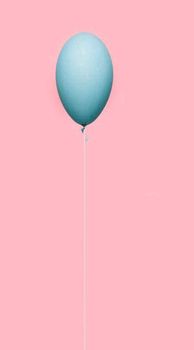 Greenish colored balloon isolated on pink colored background.