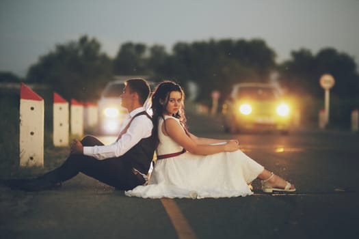 Happy bride and groom in the light of car headlights. Wedding. Happy love concept. High quality photo