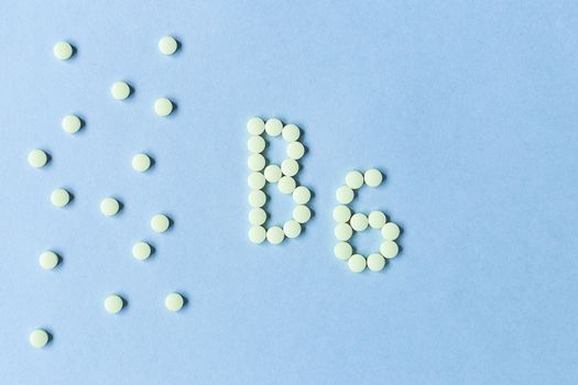 Vitamin B6 pills forming the word B6 over turquoise background, banner. free space. copy space. soft focus, blurry background. space for text. nutritional supplements, healthy food, health maintenance