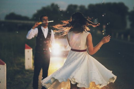 Happy bride and groom in the light of car headlights. Wedding. Happy love concept. High quality photo