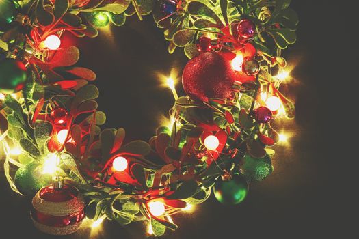 Greeting Season concept.Christmas wreath with decorative light on dark wood background