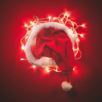 Greeting Season concept.Santa Claus hat with christmas light on red and green background