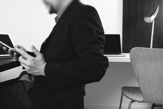 businessman working with smart phone and digital tablet and laptop computer in modern office,balck and white 