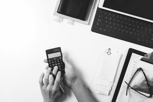 top view of businessman hand working with finances about cost and calculator and latop with mobile phone on withe desk in modern office,black with white