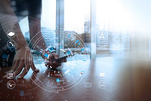 Hands of businessman using mobile phone in modern office with laptop and digital tablet computer with VR icon diagram