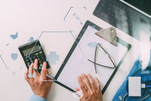 top view of Healthcare costs and fees concept.Hand of smart doctor used a calculator for medical costs in modern hospital with VR icon diagram