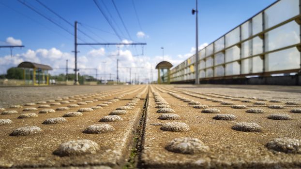 close-up of blind guiding tiles on the platform of a public transport railway station