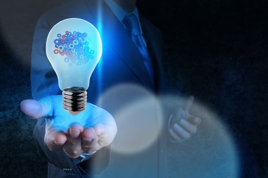 businessman hand showing light bulb with gears as concept