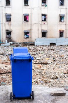 blue trashcan with old building background