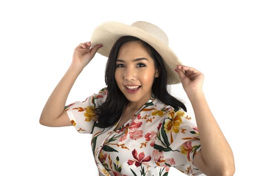 Half shot photo of pretty girl wearing floral dress holding white straw hat on her head in studio.