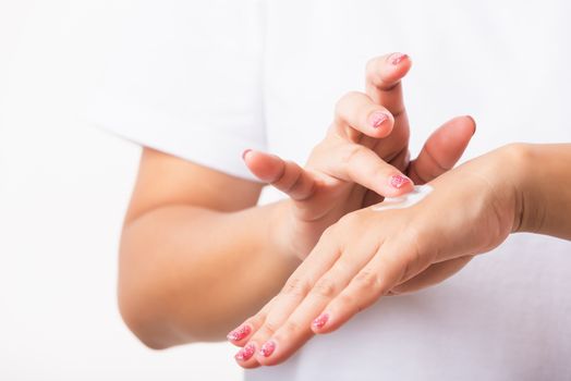 Closeup young Asian woman applying lotion cosmetic moisturizer cream on her behind the palm skin hand, studio shot isolated on white background, Healthcare medical and hygiene skin body care concept