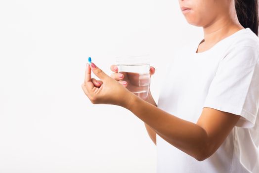 Closeup young Asian woman hold pill drugs in hand ready take medicines with a glass of water, studio shot isolated on white background, Healthcare and medical pharmacy concept