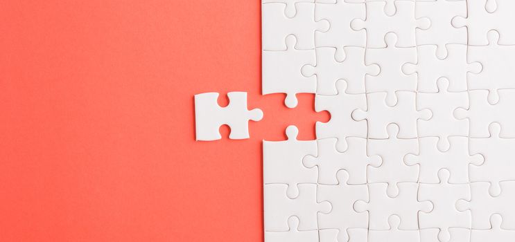 Top view flat lay of paper plain white jigsaw puzzle game texture last pieces for solve and place, studio shot on a red background, quiz calculation concept