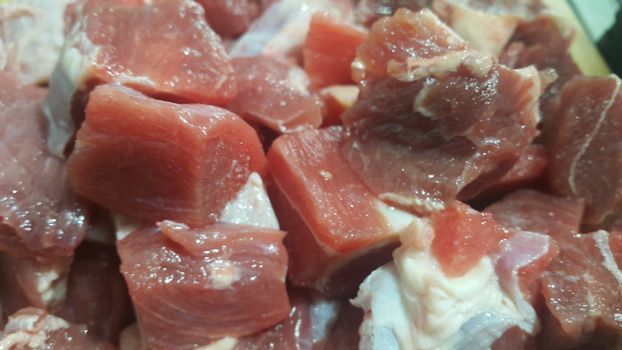 Close up view of fresh finely chopped meat cubes. Red meat small steaks with whitish meat fat.