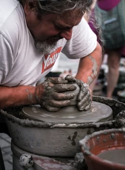 Sibiu City, Romania - 31 August 2019. Hands of a potter shaping a clay pot on a potter's wheel at the potters fair from Sibiu, Romania