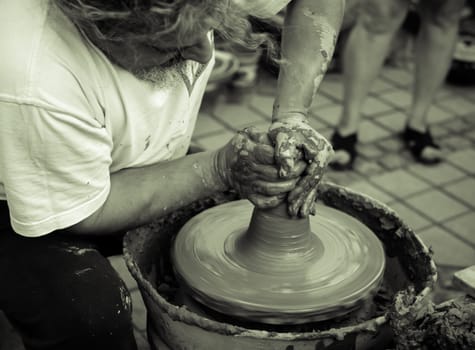 Sibiu City, Romania - 31 August 2019. Hands of a potter shaping a clay pot on a potter's wheel at the potters fair from Sibiu, Romania