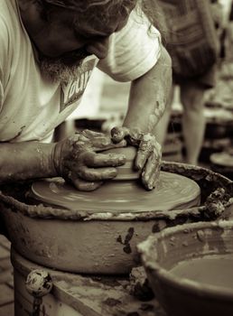 Sibiu City, Romania - 31 August 2019. Hands of a potter shaping a clay pot on a potter's wheel at the potters fair from Sibiu, Romania