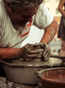 Sibiu City, Romania - 31 August 2019. Hands of a potter shaping a clay pot on a potter's wheel at the potters fair from Sibiu, Romania