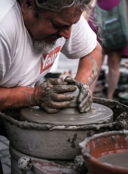 Sibiu City, Romania - 31 August 2019. Hands of a potter shaping a clay pot on a potter's wheel at the potters fair from Sibiu, Romania