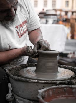 Sibiu City, Romania - 31 August 2019. Hands of a potter shaping a clay pot on a potter's wheel at the potters fair from Sibiu, Romania