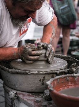 Sibiu City, Romania - 31 August 2019. Hands of a potter shaping a clay pot on a potter's wheel at the potters fair from Sibiu, Romania