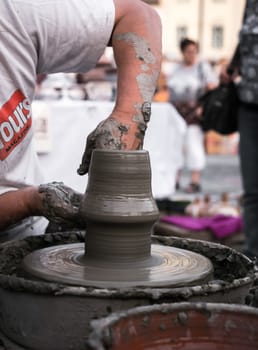 Sibiu City, Romania - 31 August 2019. Hands of a potter shaping a clay pot on a potter's wheel at the potters fair from Sibiu, Romania