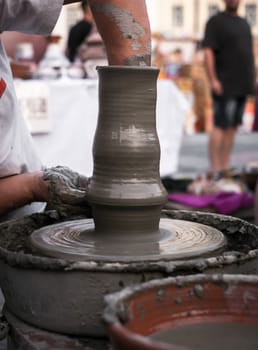 Sibiu City, Romania - 31 August 2019. Hands of a potter shaping a clay pot on a potter's wheel at the potters fair from Sibiu, Romania