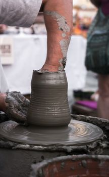 Sibiu City, Romania - 31 August 2019. Hands of a potter shaping a clay pot on a potter's wheel at the potters fair from Sibiu, Romania