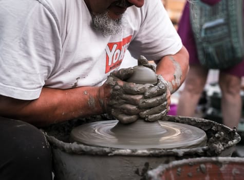 Sibiu City, Romania - 31 August 2019. Hands of a potter shaping a clay pot on a potter's wheel at the potters fair from Sibiu, Romania