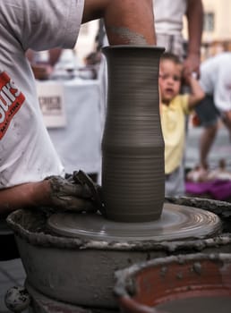 Sibiu City, Romania - 31 August 2019. Hands of a potter shaping a clay pot on a potter's wheel at the potters fair from Sibiu, Romania