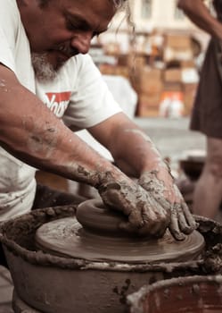 Sibiu City, Romania - 31 August 2019. Hands of a potter shaping a clay pot on a potter's wheel at the potters fair from Sibiu, Romania