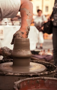 Sibiu City, Romania - 31 August 2019. Hands of a potter shaping a clay pot on a potter's wheel at the potters fair from Sibiu, Romania