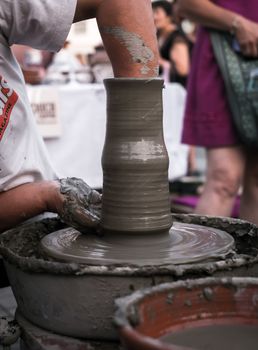 Sibiu City, Romania - 31 August 2019. Hands of a potter shaping a clay pot on a potter's wheel at the potters fair from Sibiu, Romania