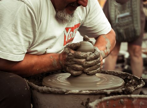 Sibiu City, Romania - 31 August 2019. Hands of a potter shaping a clay pot on a potter's wheel at the potters fair from Sibiu, Romania