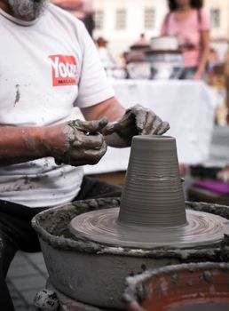 Sibiu City, Romania - 31 August 2019. Hands of a potter shaping a clay pot on a potter's wheel at the potters fair from Sibiu, Romania