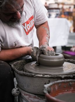 Sibiu City, Romania - 31 August 2019. Hands of a potter shaping a clay pot on a potter's wheel at the potters fair from Sibiu, Romania