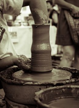 Sibiu City, Romania - 31 August 2019. Hands of a potter shaping a clay pot on a potter's wheel at the potters fair from Sibiu, Romania