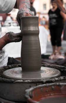 Sibiu City, Romania - 31 August 2019. Hands of a potter shaping a clay pot on a potter's wheel at the potters fair from Sibiu, Romania